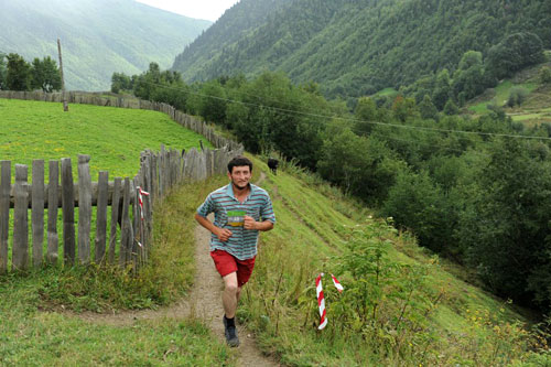 Tredjemann i seniorklassen Gela Calani passerer den smale stien ved elva Dolra. Arrang&oslash;rfoto.