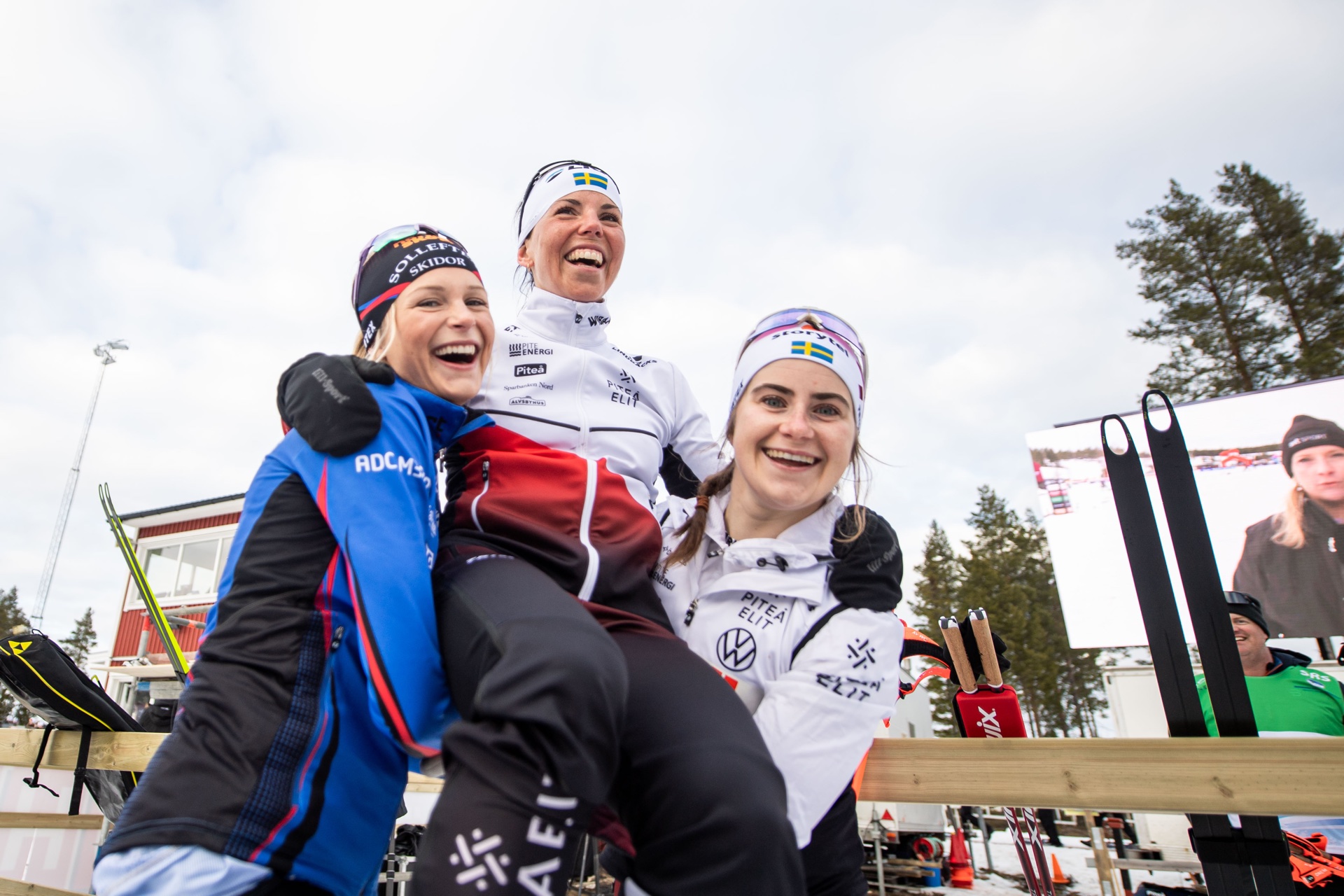 Frida Karlsson och Ebba Andersson lyfter upp vinnaren Charlotte Kalla. Foto: Maxim Thore/Bildbyrån.